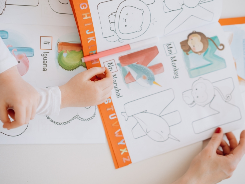 Children learning with alphabet worksheets, highlighting the importance of personalised care plans in early education.