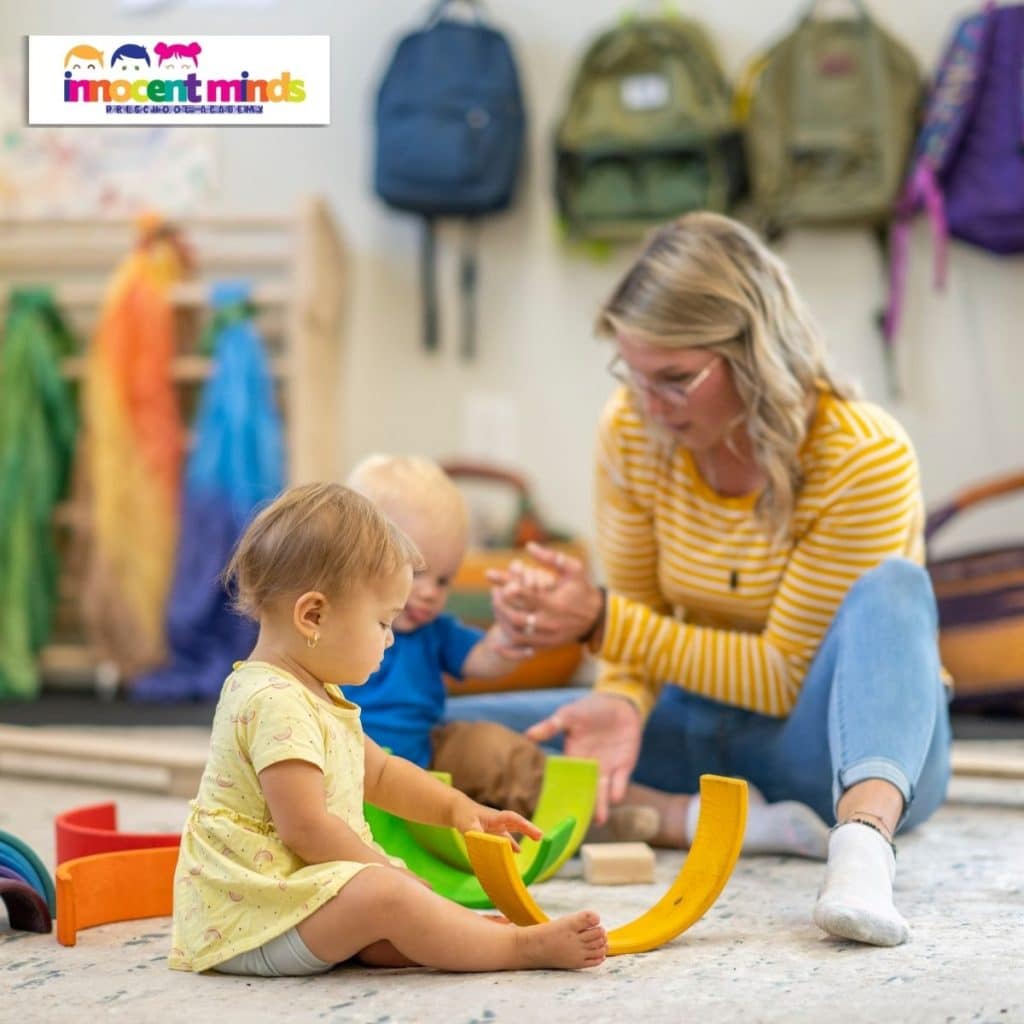 A teacher guiding toddlers as they explore colourful toys and interactive play in a learning space