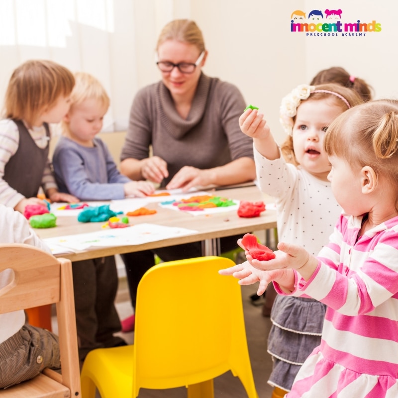 A classroom filled with toddlers happily playing with toys, fostering learning and creativity in a toddler program.