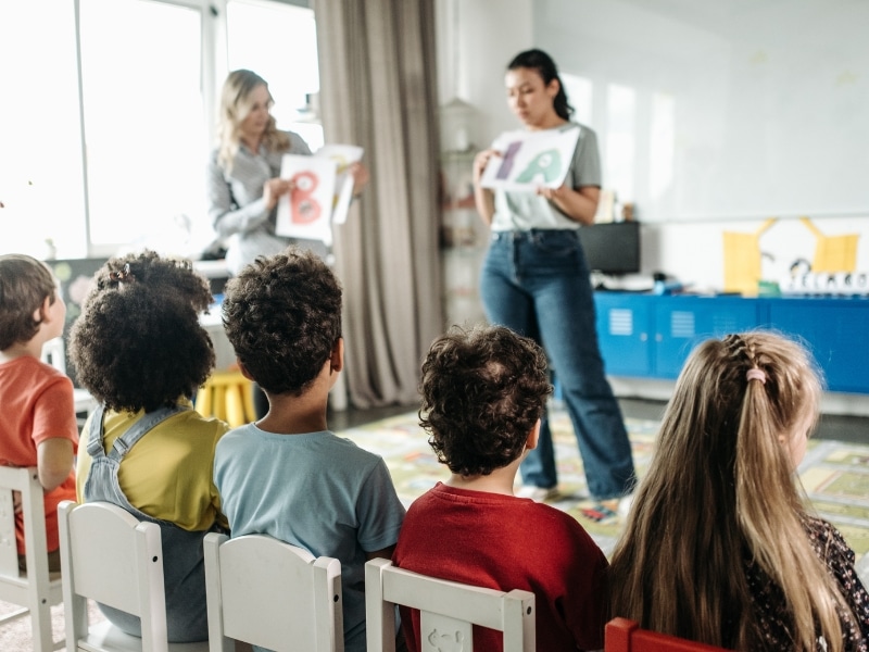 A teacher introducing phonics to young children, emphasizing the significance of early childhood education in literacy development.