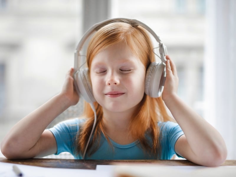 A girl listening to soothing music as part of emotional regulation strategies for relaxation and stress relief.