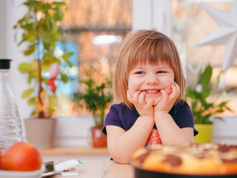 Happy toddler smiling, demonstrating emotional regulation strategies for managing feelings and emotions.