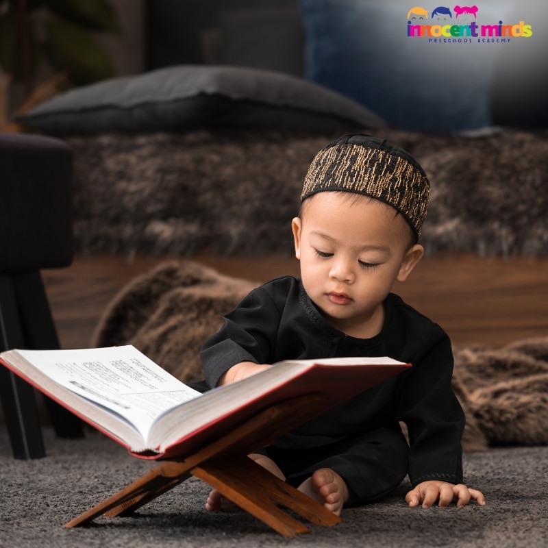 "Young boy in traditional attire reading the Quran on a wooden stand – Quran Learning Program for Kids