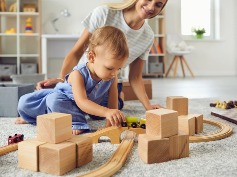 Child engaging in play with blocks and trains as part of the best learning programs for toddlers