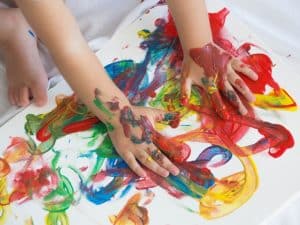Finger painting with bright colours used in the best learning programs for toddlers to enhance creativity